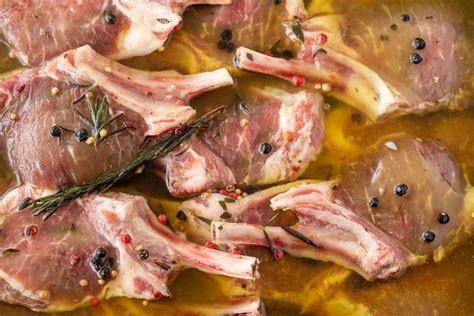 Ingredienti per la marinatura dell'agnello: olio d'oliva, vino bianco, aglio, bacche di ginepro, rosmarino, timo, alloro