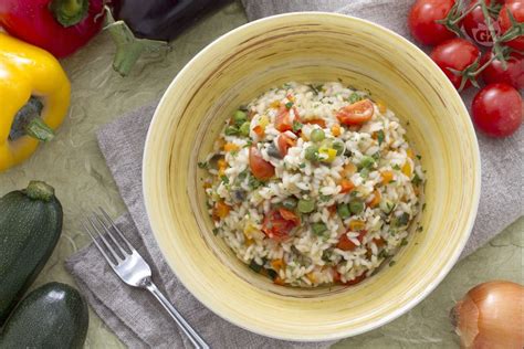 Ingredienti per un risotto alle verdure, con riso, insalata e brodo.
