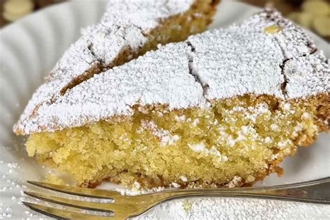 Immagine della Torta Caprese al Limone finita, con zucchero a velo e fettine di limone come decorazione