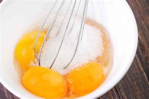Inquadratura ravvicinata della ciotola con i tuorli, lo zucchero e la scorza di limone, prima di aggiungere il cioccolato