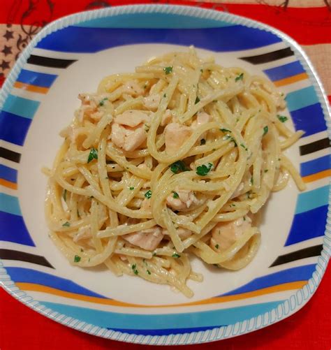 padella con spaghetti, salmone e baccalà che si insaporiscono