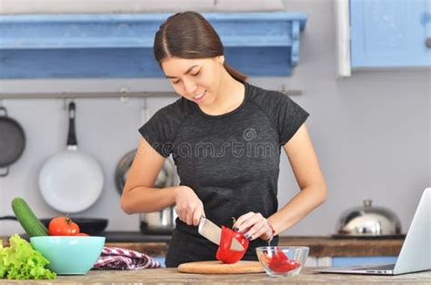 Una giovane donna sorride mentre cucina in una cucina moderna