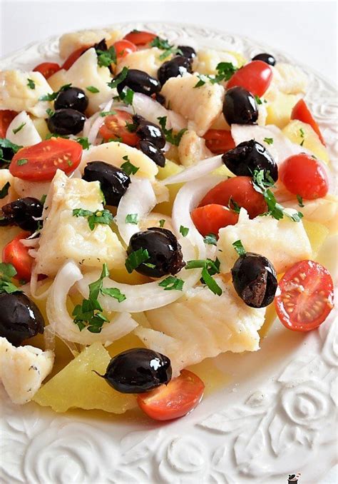 Immagine di un piatto di insalata di baccalà fresco e colorato con verdure e olive