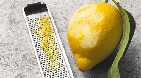 Un primo piano della scorza di limone grattugiata, ingrediente chiave per l'aroma.