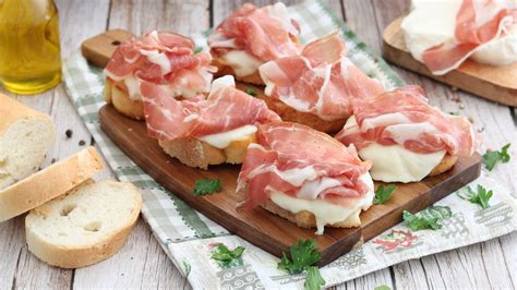 Immagine di crostini con prosciutto e mozzarella filante appena sfornati