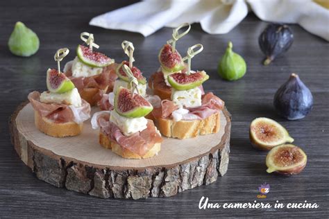 Immagine di crostini con fichi freschi, prosciutto crudo e foglie di menta