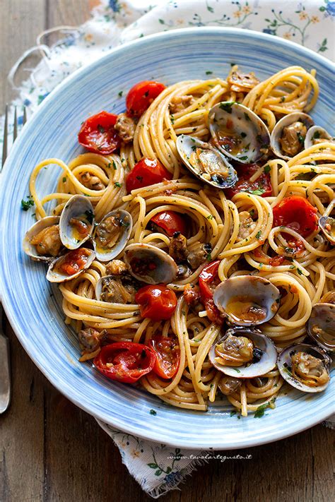 padella con spaghetti alle vongole che vengono mantecati