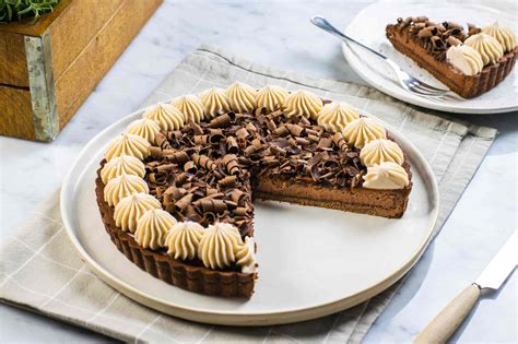 Immagine di una torta di castagne decorata con ciuffetti di crema e granella.