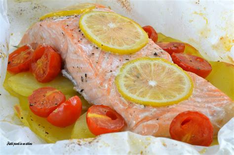 Un filetto di salmone cotto al forno in un cartoccio aperto, con fette di limone e erbe aromatiche.