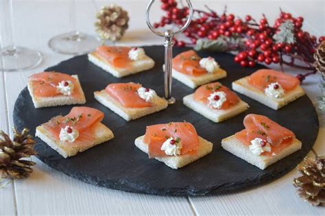 Un vassoio con diversi antipasti a base di salmone affumicato, come involtini, tartine e mousse.