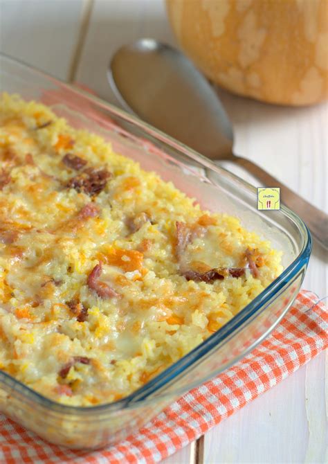 Ingredienti per il riso al forno disposti ordinatamente in ciotole separate: riso Arborio, pomodori pelati, cipolla, aglio, formaggi misti (mozzarella, parmigiano), erbe aromatiche.