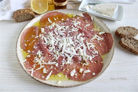 Scaglie di formaggio stagionato su carpaccio di manzo