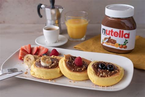 Soufflé pancake giapponesi guarniti con Nutella, granella di nocciole e frutta fresca.