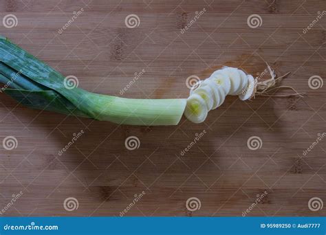 un porro fresco tagliato a rondelle su un tagliere di legno