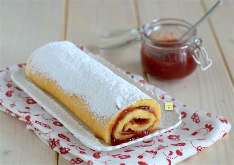 Immagine di un rotolo farcito con marmellata di limone, tagliato a fette, che mostra la consistenza soffice della pasta biscotto e il ripieno.