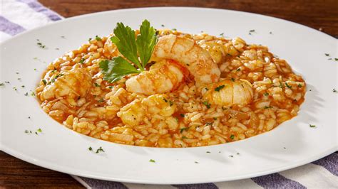 Immagine ravvicinata di un piatto di risotto fragole e scampi, ben presentato con guarnizioni colorate.