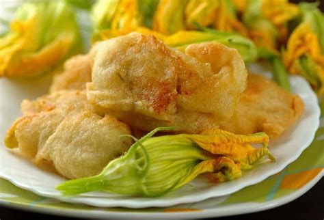 Fiori di zucca fritti dorati e croccanti appena scolati su carta assorbente