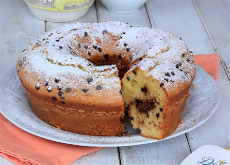 Una ciambella al kamut ricca di ciliegie e gocce di cioccolato, vista dall'alto.