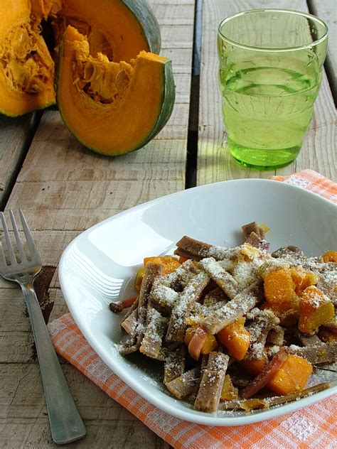 Piatto finito di pizzoccheri con zucca, speck e scaglie di formaggio