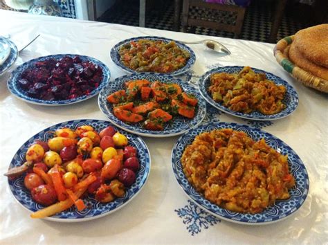 Un assortimento colorato di antipasti marocchini, tra cui insalate, olive e pane.
