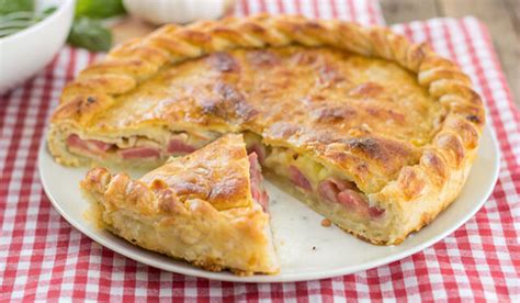 una fetta di torta salata prosciutto e formaggio tagliata, mostrando il ripieno filante di formaggio e prosciutto cotto