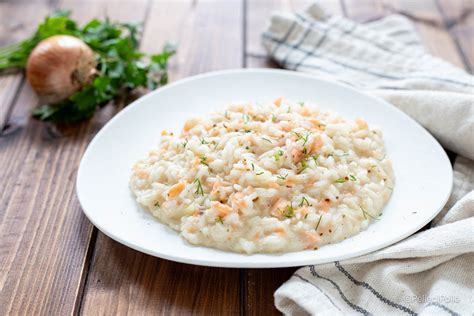 Immagine di un risotto al salmone affumicato pronto per essere servito, con guarnizione di prezzemolo tritato.
