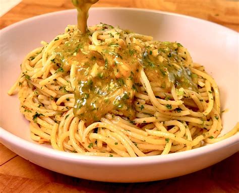 Un frullatore con peperoncini, aglio e olio, pronto per essere azionato.