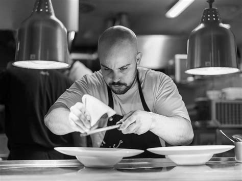 Jacopo Ticchi in cucina, che prepara un piatto di pesce