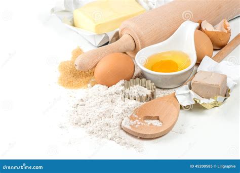 Immagine dei vari ingredienti disposti sul piano di lavoro: farina, zuccheri, burro, uova, nocciole, gocce di cioccolato.