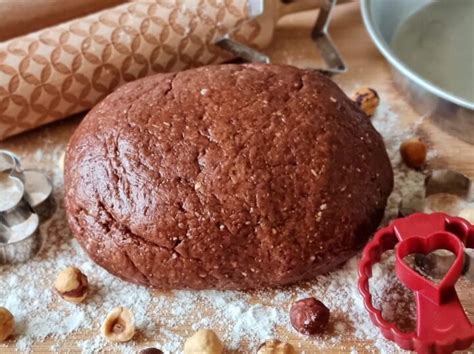 Primo piano di un cookie al cacao con nocciole, appena sfornato, con gocce di cioccolato fuso che cola.