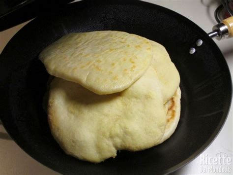 Una padella antiaderente con una pita che si sta gonfiando durante la cottura.