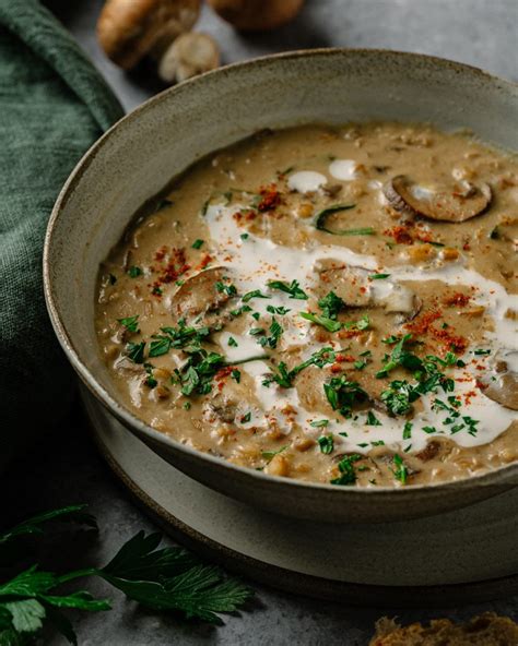 Immagine di una zuppa di funghi fumante con pancetta croccante e erbe aromatiche