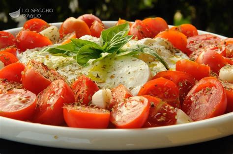 Piatto di mozzarella di bufala con pomodori arrosto e pesto di pistacchi