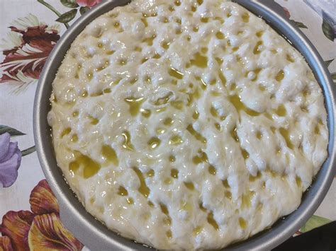 Immagine di una focaccia genovese dorata e fragrante con i tipici buchi in superficie