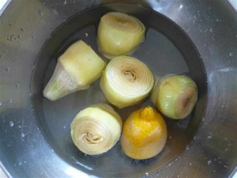 Carciofi puliti e immersi in acqua e limone per evitare l'ossidazione