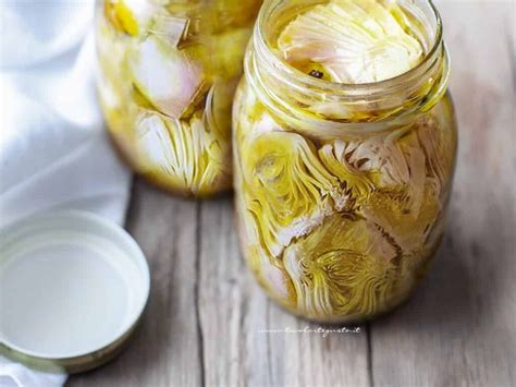 Vasetti di vetro riempiti con carciofi sott'olio e coperti di olio
