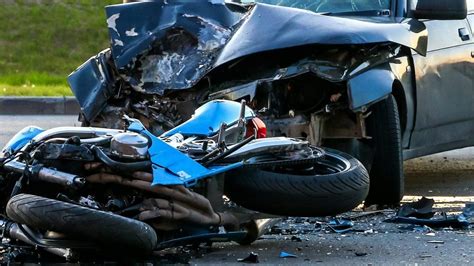 immagine di un'auto e una moto incidentate sulla strada