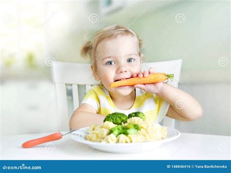 Bambino che mangia felicemente un piatto di zucchine