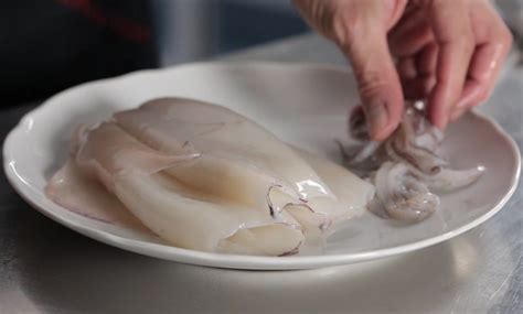 Infografica che illustra i passaggi chiave per pulire i calamari, mostrando come rimuovere pelle, interiora, cartilagine e tentacoli.