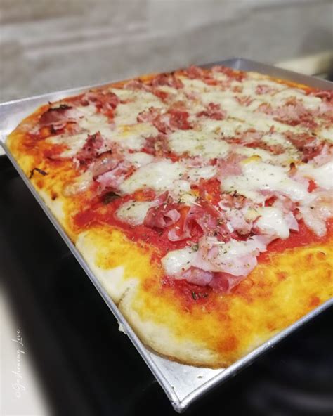 Immagine di una pizza in teglia alta e soffice, appena sfornata