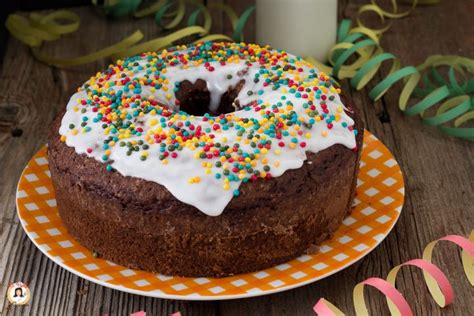 Una ciambella al cacao glassata con zuccherini colorati, pronta per una festa.