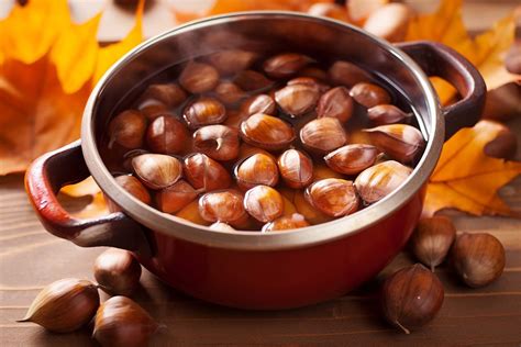 Fotografia di castagne bollite in un cesto, con vaporoso fumo che sale