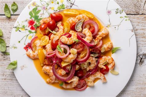 Primo piano di un'insalata catalana di gamberi splendidamente impiattata con guarnizioni fresche
