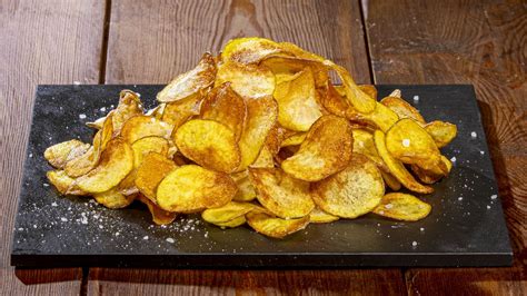 Immagine: Ravioli di melanzane finemente impiattati con chips di patate blu e salsa verde