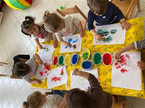 Un gruppo di bambini che partecipa a un laboratorio di pittura delle zucche, con colori e pennelli a disposizione.