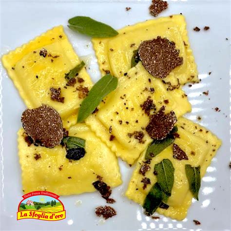 Immagine di ravioli al tartufo serviti con scaglie di tartufo fresco e una salsa cremosa