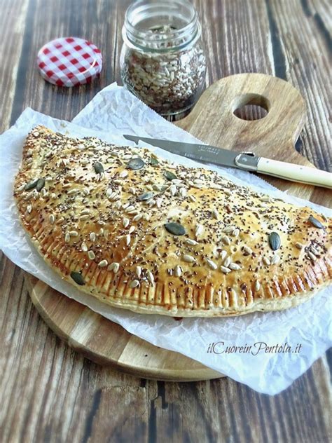 Un primo piano sull'impasto per il calzone che riposa in una ciotola, coperto da un canovaccio.