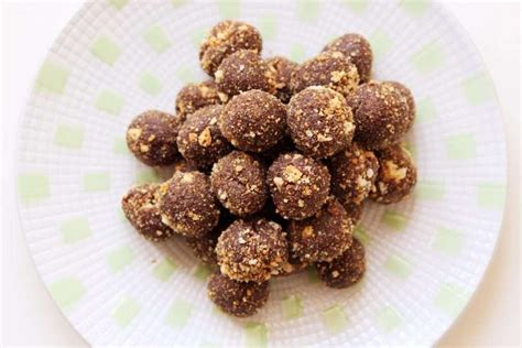 Foto di diverse palline di mandorle senza cottura, alcune cosparse di zucchero a velo, altre di zucchero semolato, altre ancora di cacao.