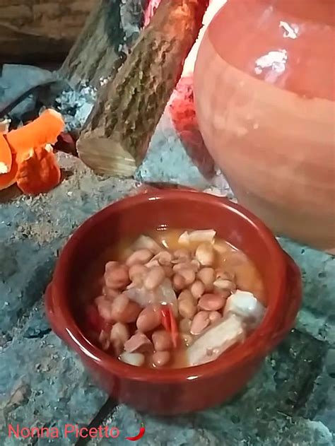 Nonna Peppa che cucina fagioli in una pignatta sul caminetto