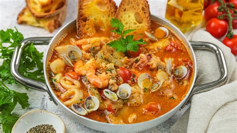 Ingredienti freschi per il brodetto: pomodori, peperoni, aglio, prezzemolo e una varietà di pesce fresco